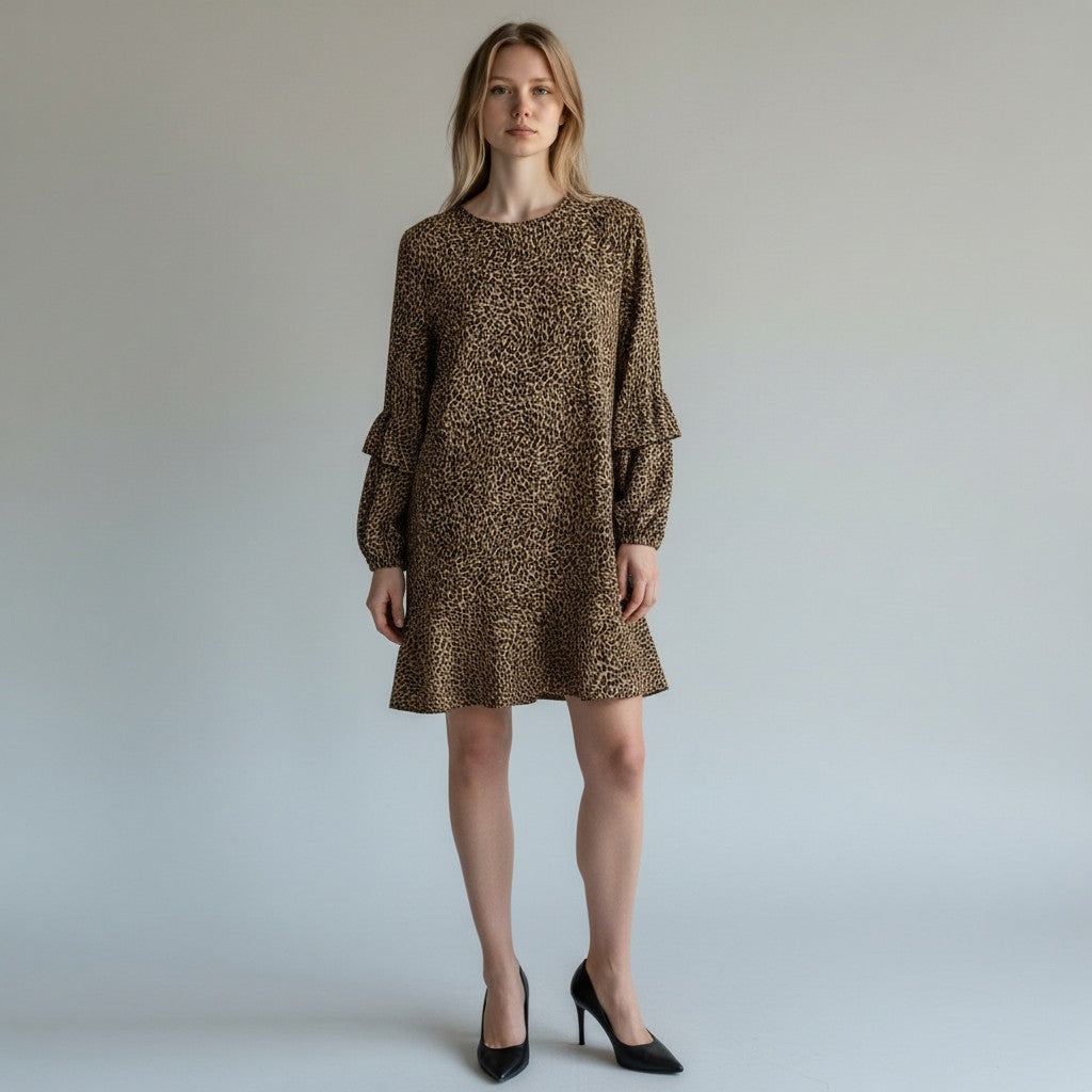 A woman modeling a brown and black leopard-print mini dress with long tiered sleeves, paired with black high heels, against a neutral light gray studio background.