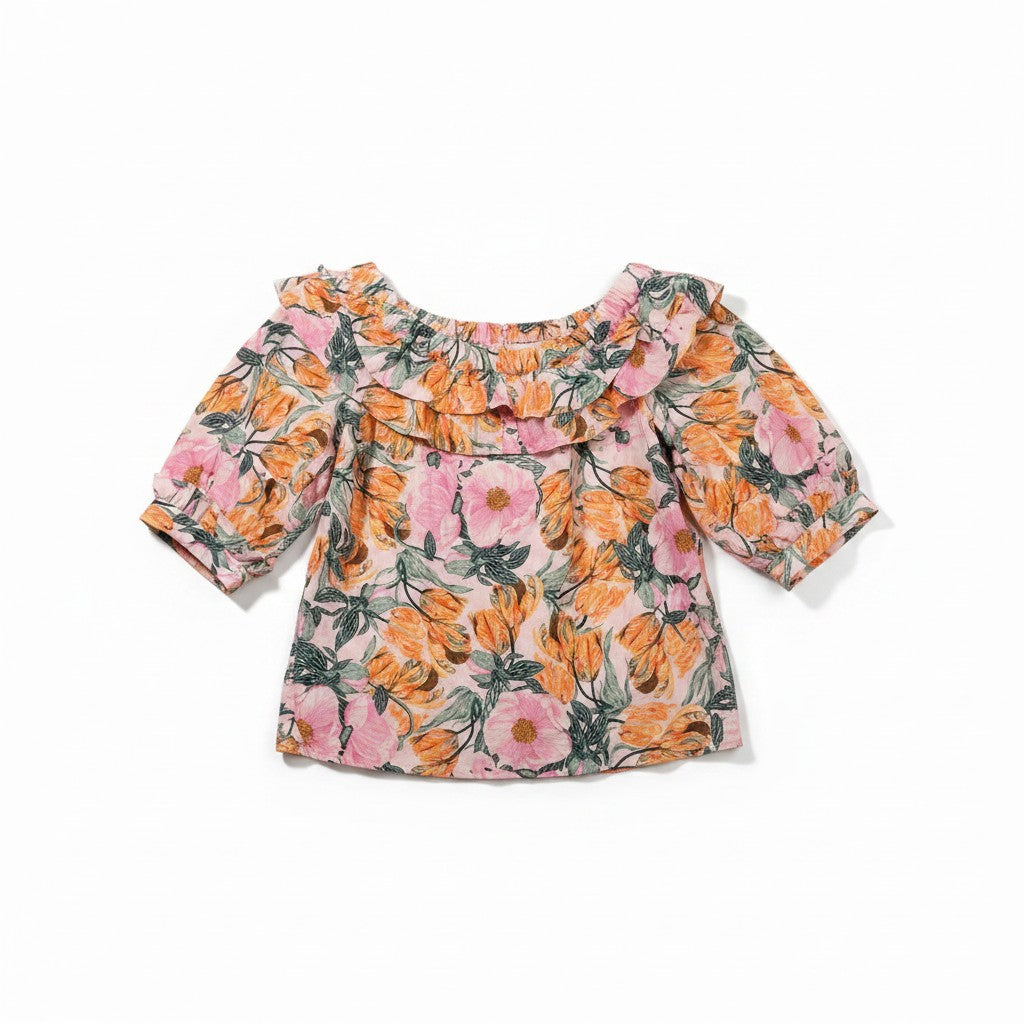 A short-sleeve baby top with a ruffled off-the-shoulder neckline, featuring a vibrant floral print in pink, orange, and green on a light beige background.