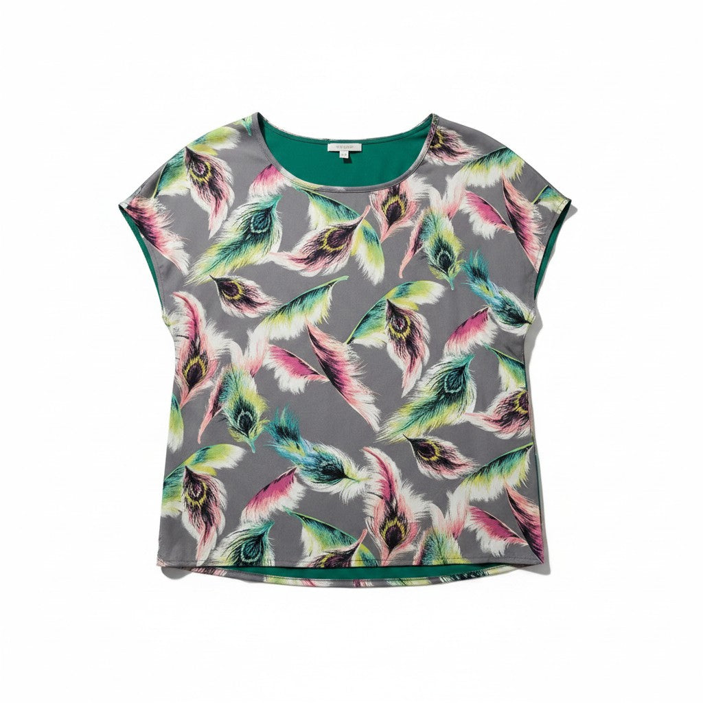 A gray short-sleeve top with a colorful peacock feather print, featuring a solid green inner collar and hem, laid flat on a white background.