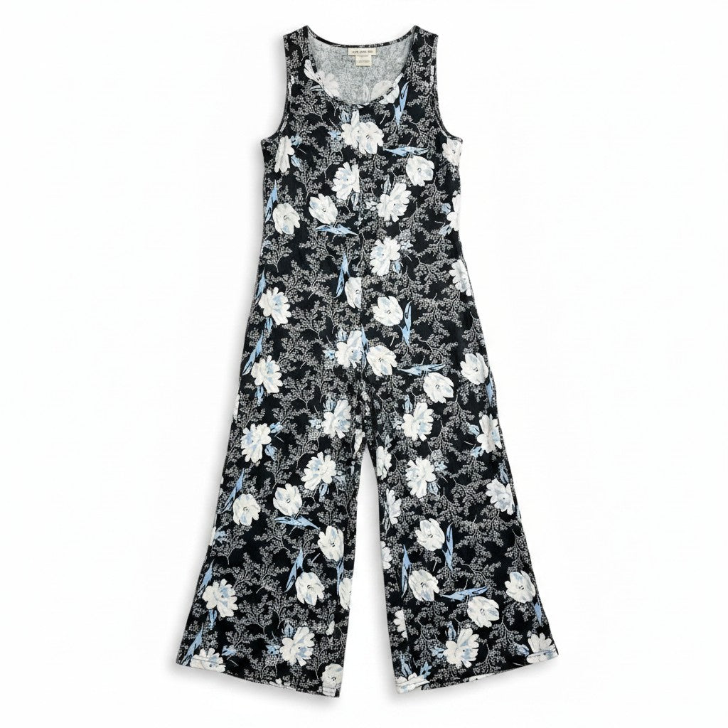 A sleeveless wide-leg jumpsuit with a black base and a white floral pattern, displayed flat against a white background.