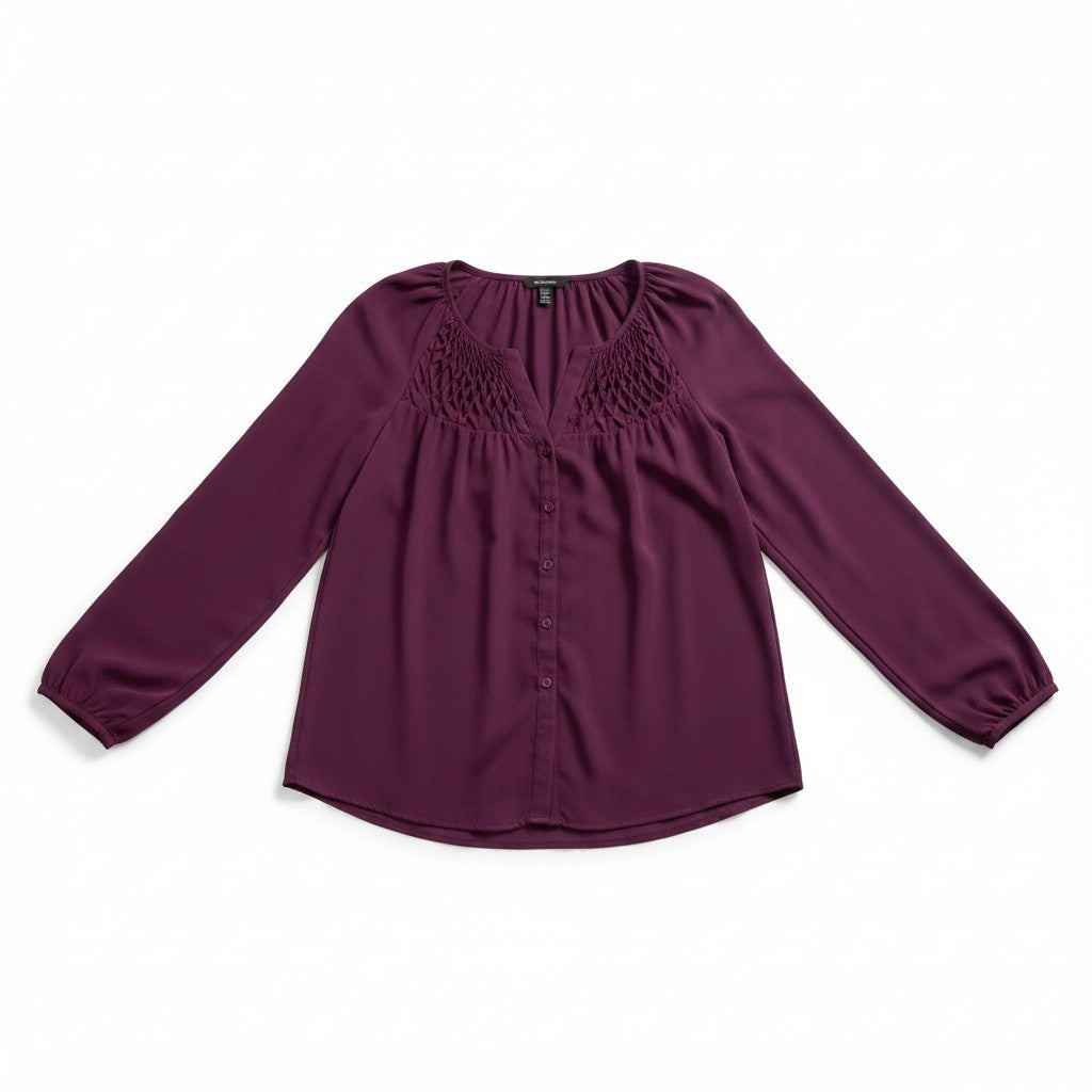 A long-sleeve button-up blouse in deep plum purple, featuring a gathered, textured yoke at the neckline and elasticized cuffs, laid flat on a white background.