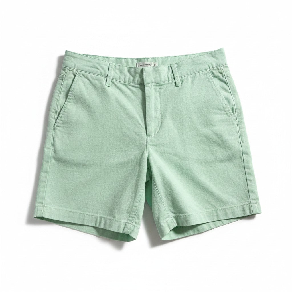 A pair of light mint green chino shorts with a classic five-pocket design and belt loops, laid flat on a white background.