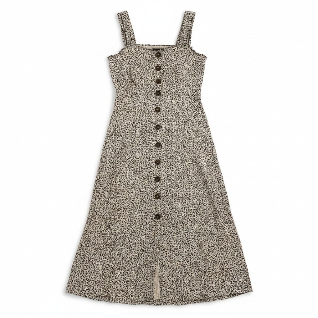 A tan and black spotted dress on a light background.