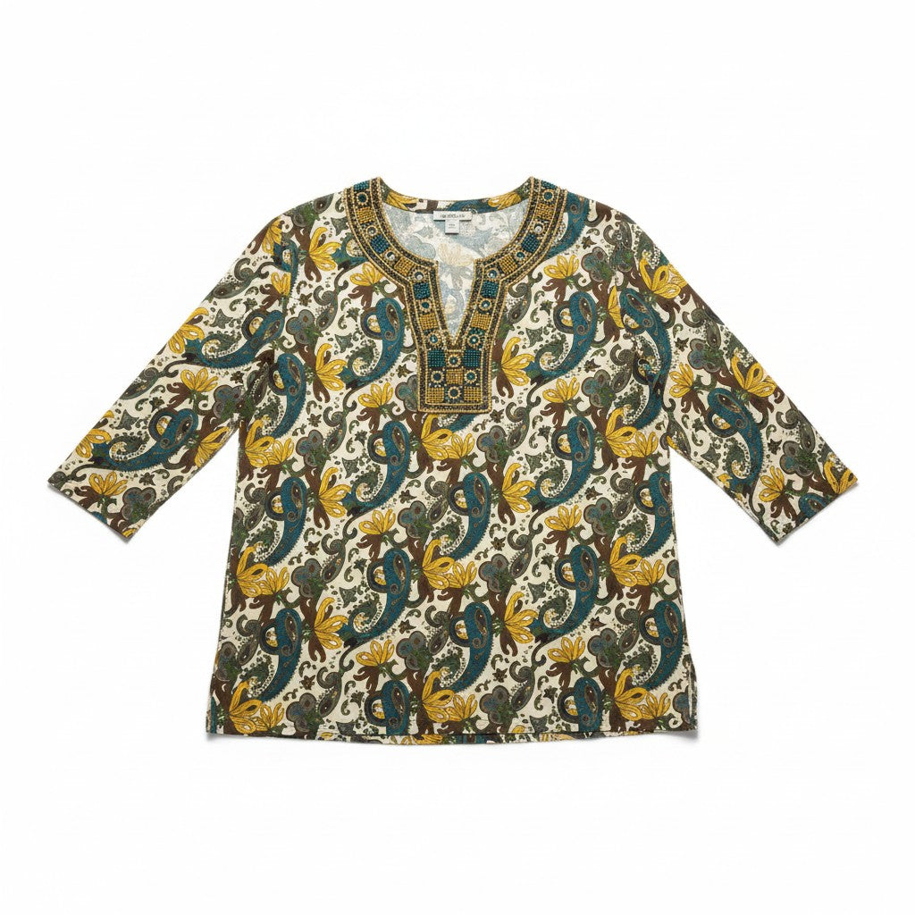A women's long-sleeve tunic top with a detailed paisley and floral print in teal, mustard yellow, olive green, and brown on a cream background, featuring a decorative geometric neckline.