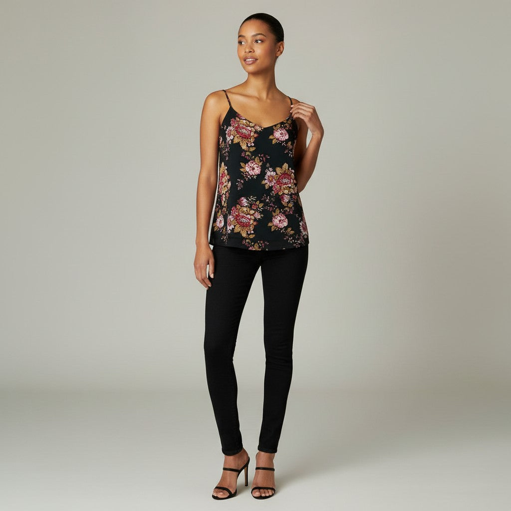 A black spaghetti-strap camisole top with a red, pink, and gold floral pattern, displayed on a cream mannequin torso against a wrinkled white backdrop.