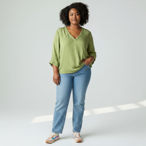 Woman wearing a green top and blue jeans on a white background