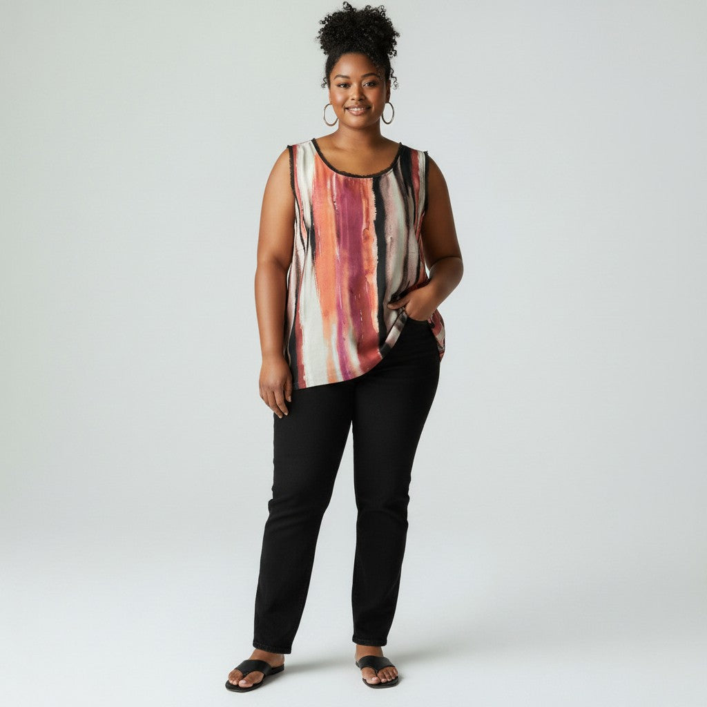 A woman modeling a sleeveless top with an abstract vertical stripe pattern in pink, red, orange, and cream, paired with black pants and sandals, against a light gray studio background.