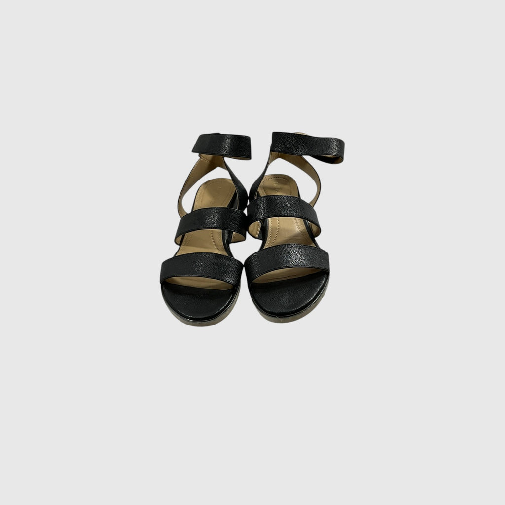 A pair of black leather strappy sandals with ankle straps and low block heels, shown from a top-down view on a light gray background.