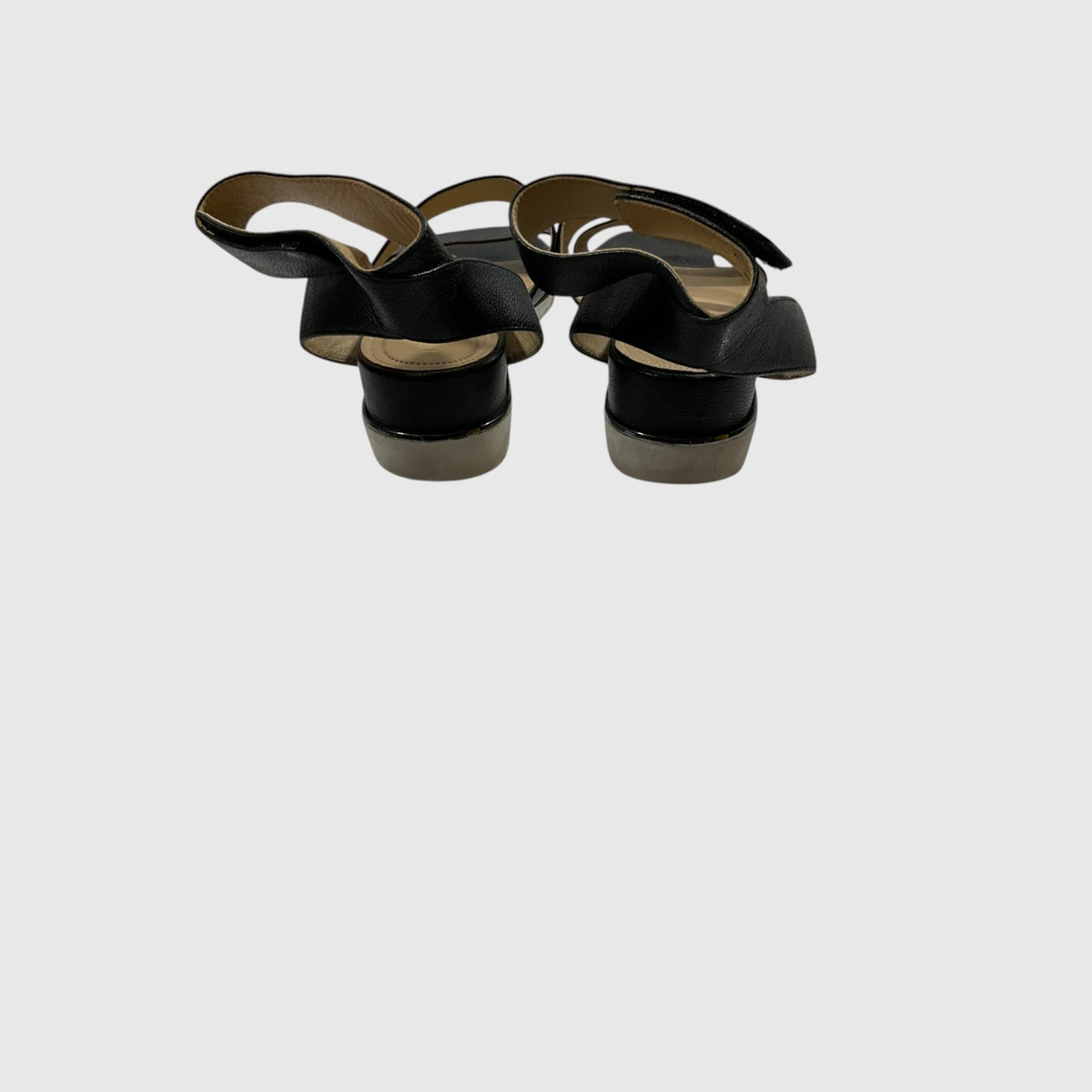 A pair of black leather slingback sandals with low block heels, shown from a top-down view on a light gray background.