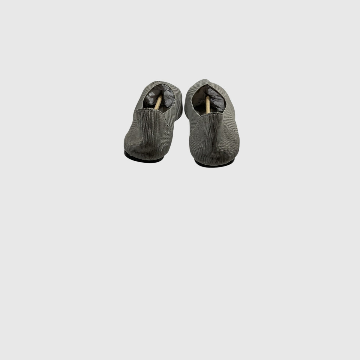 A pair of dark gray slip-on shoes with a textured fabric upper and black soles, shown from a top-down view on a light gray background.