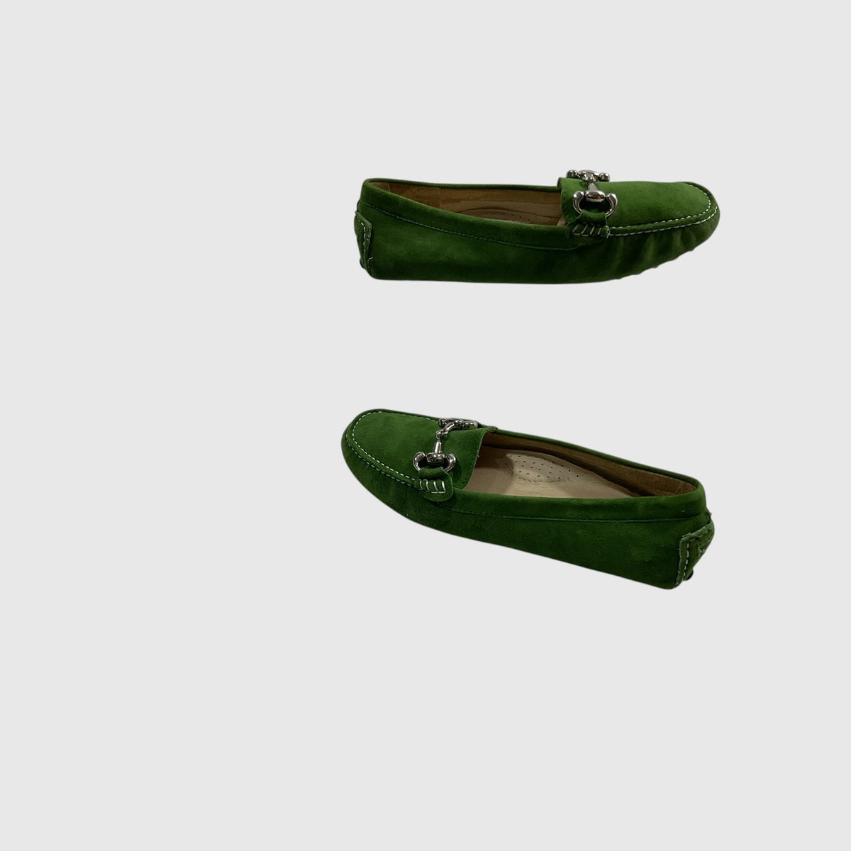 A pair of green suede loafer-miocas with silver-tone horsebit hardware, shown from two angles (side and top-down) against a light gray background.