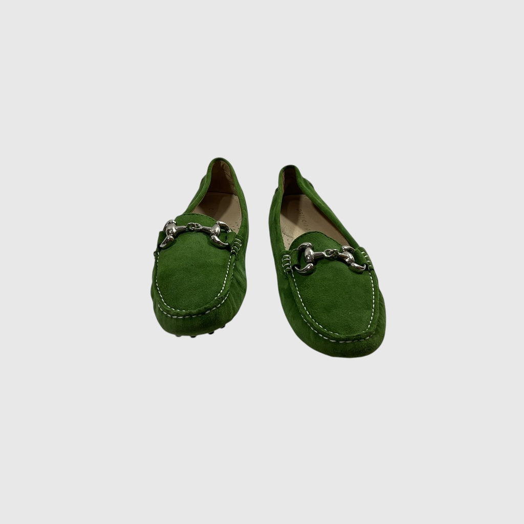 A pair of green suede loafers with silver horsebit hardware across the vamp, displayed on a light gray background.