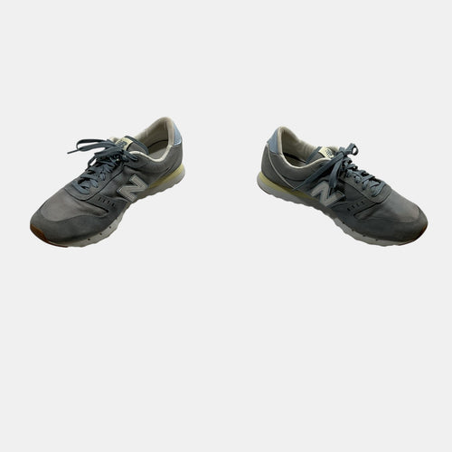 grey and blue New Balance Sneakers on a white background
