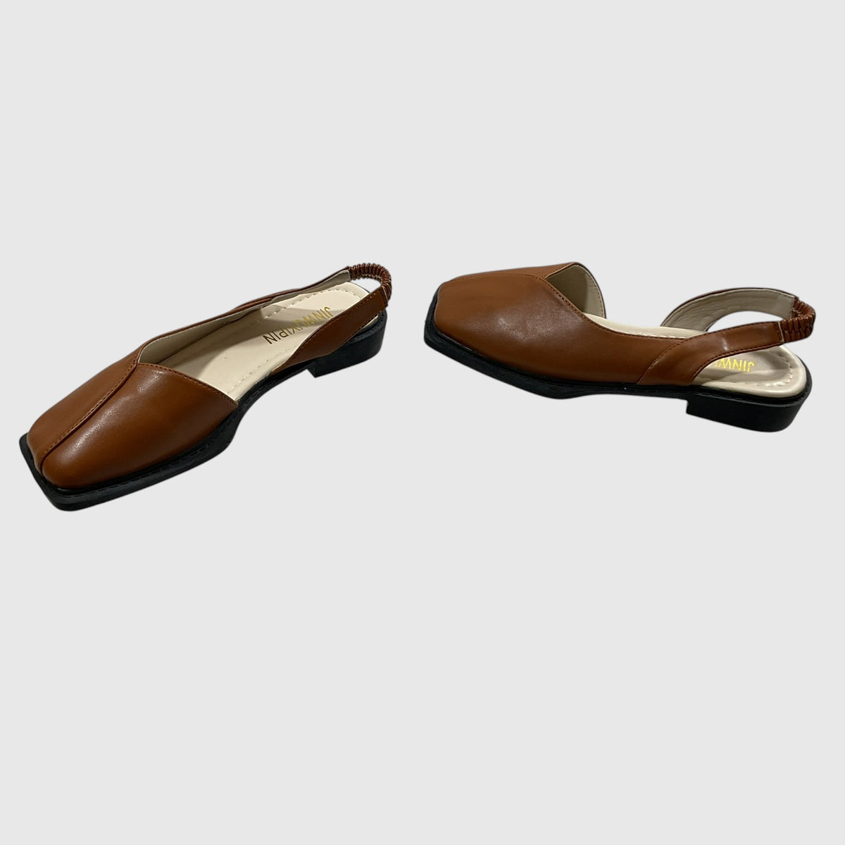 A pair of brown leather slingback flats with square toes and low black block heels, shown from two angles on a light gray background.