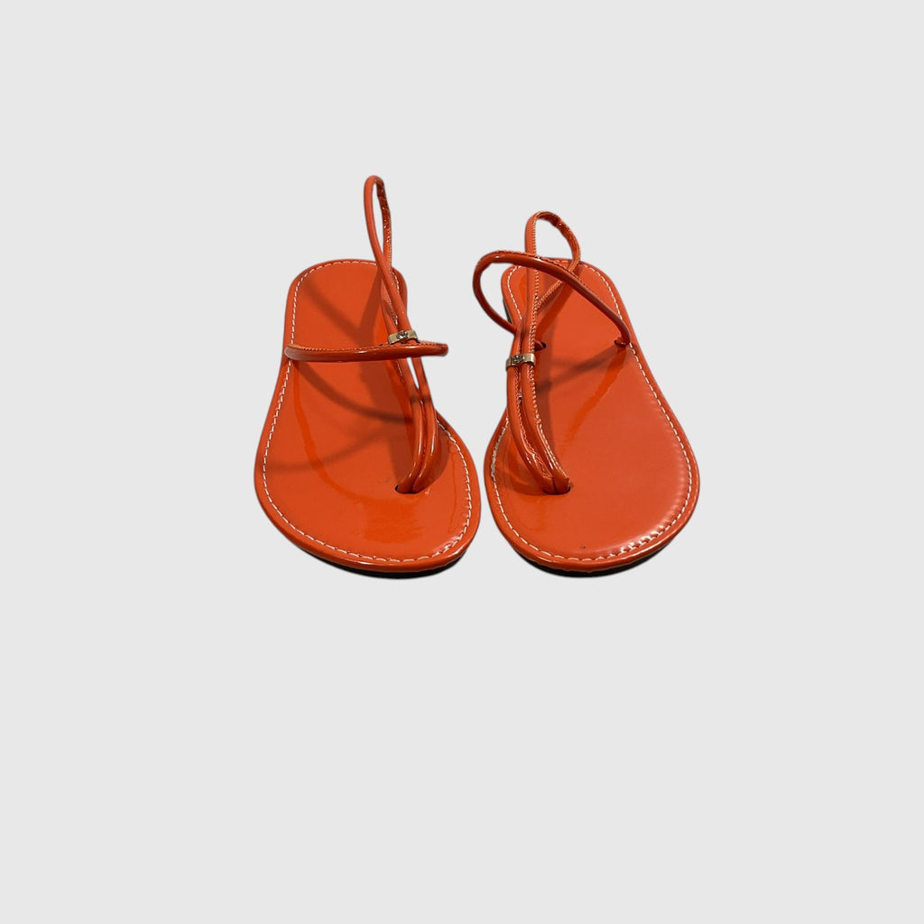 A pair of bright orange patent leather thong sandals with thin straps and small gold-tone buckle details, displayed on a light gray background.