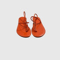 A pair of bright orange patent leather thong sandals with thin straps and small gold-tone buckle details, displayed on a light gray background.