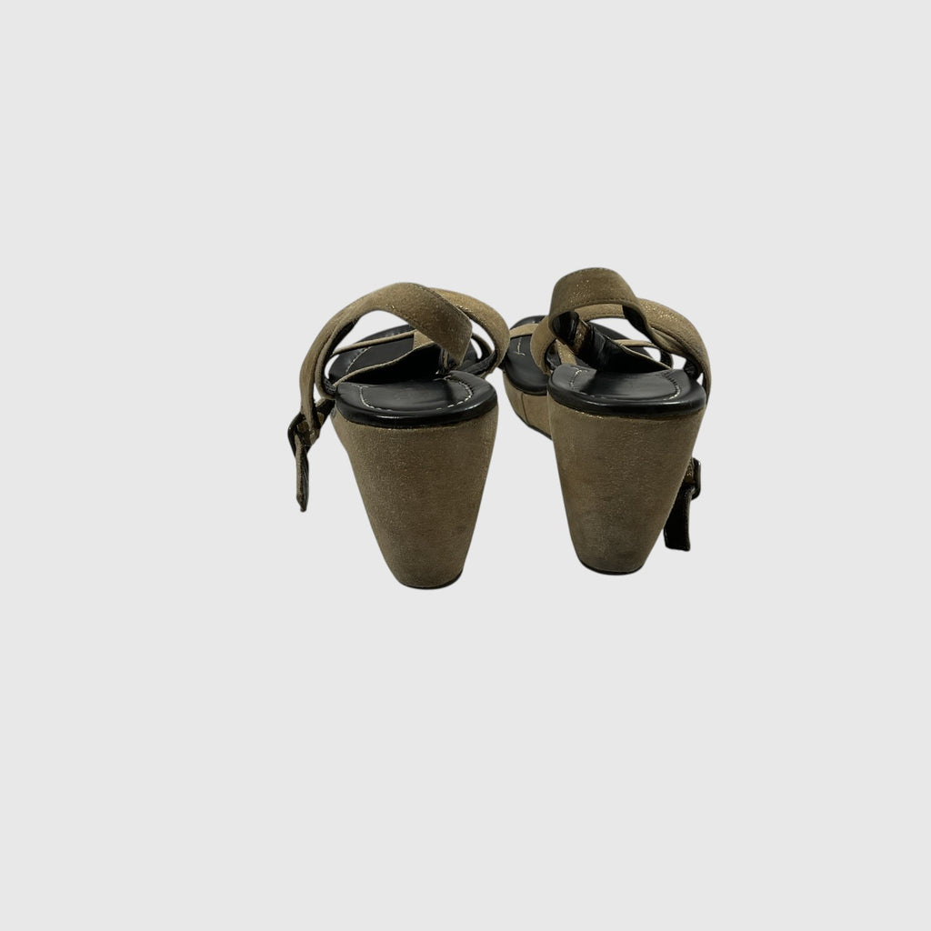 A pair of women's wedge sandals in taupe-brown suede-like material with black trim and straps, shown from the back angles on a light gray background.