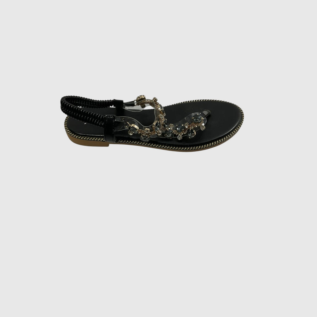 A single black flat thong sandal with a decorative strap featuring clear rhinestones and a black ankle strap, shown against a light gray background.