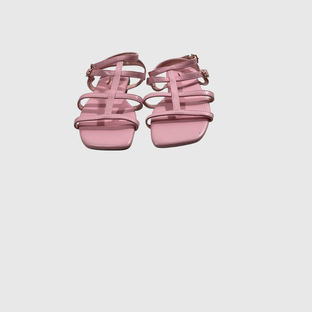 A pair of light pink strappy flat sandals with square toes and adjustable ankle straps, shown from a top-down view on a light gray background.