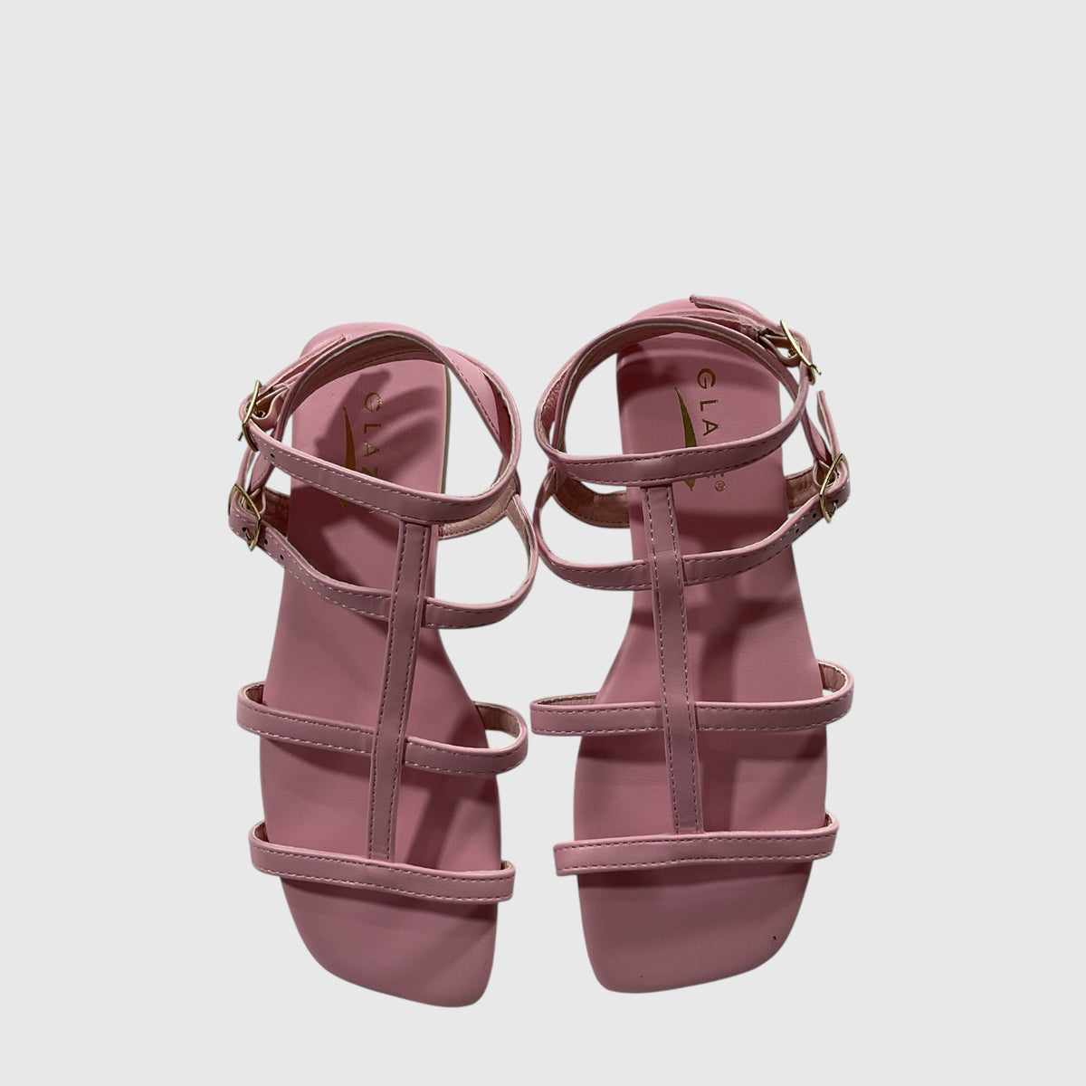 A pair of dusty pink flat sandals with multiple thin straps and gold-tone buckle details, shown from a top-down view on a light gray background.