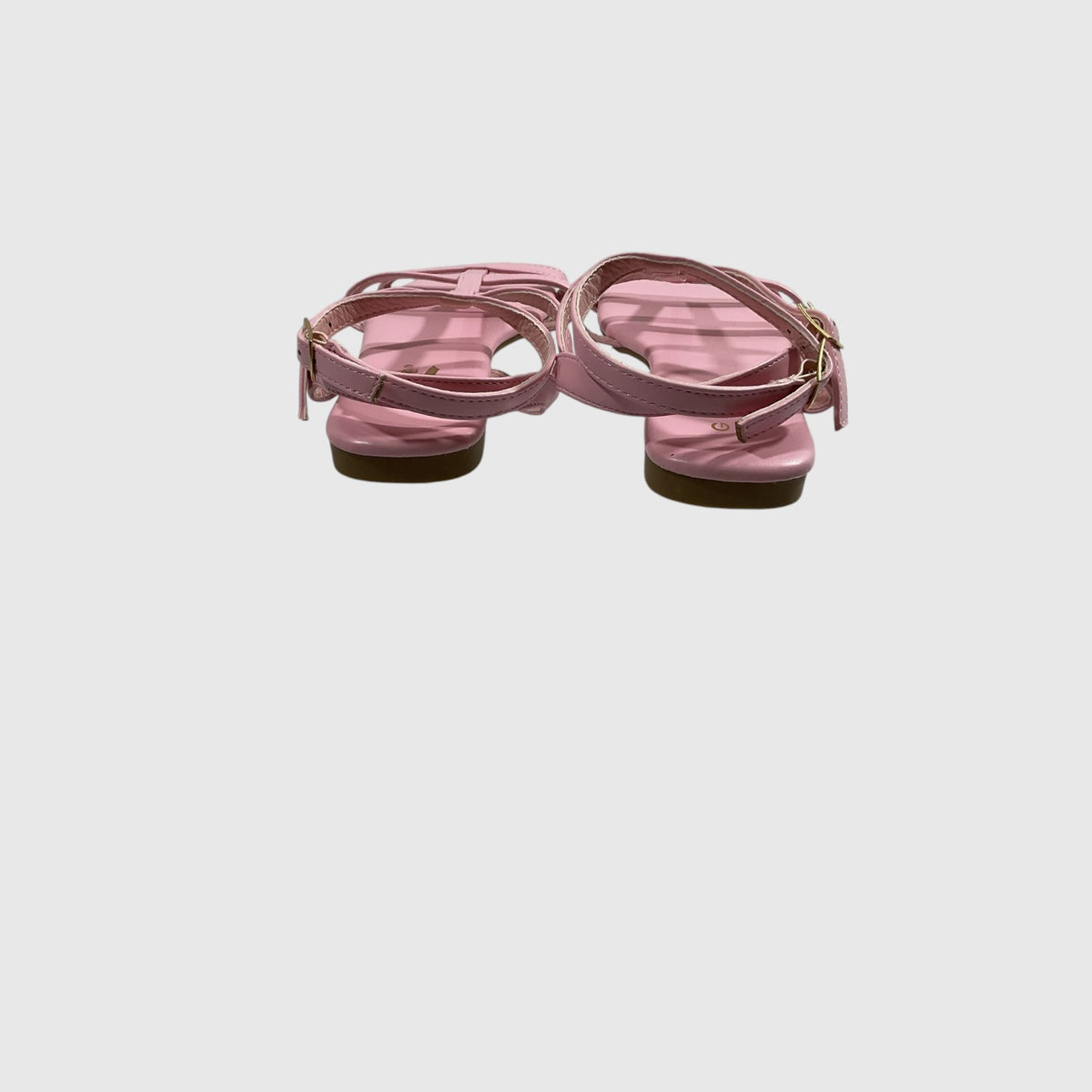 A pair of women's strappy flat sandals in dusty pink faux leather, shown from the back against a light gray background.
