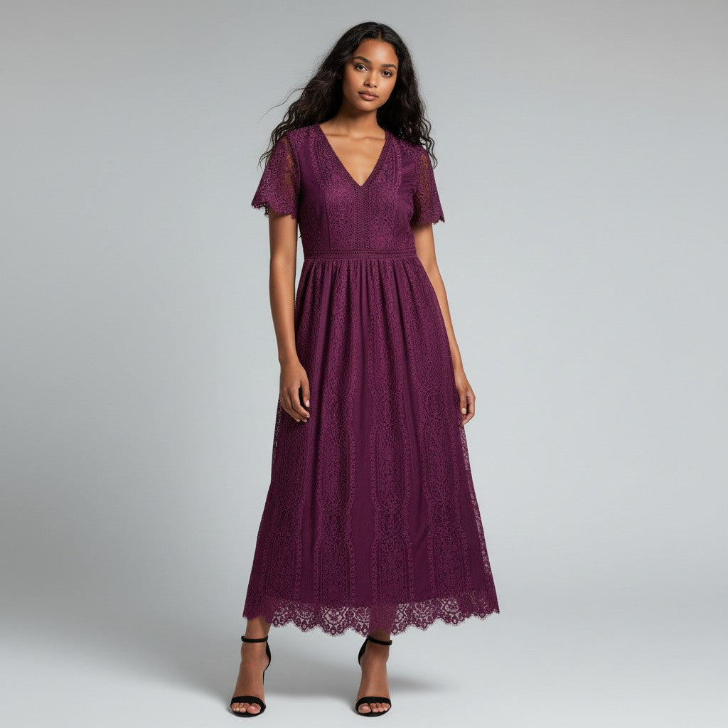 A woman wearing a short-sleeve midi dress in deep burgundy lace, paired with black strappy heels, against a light gray studio background.