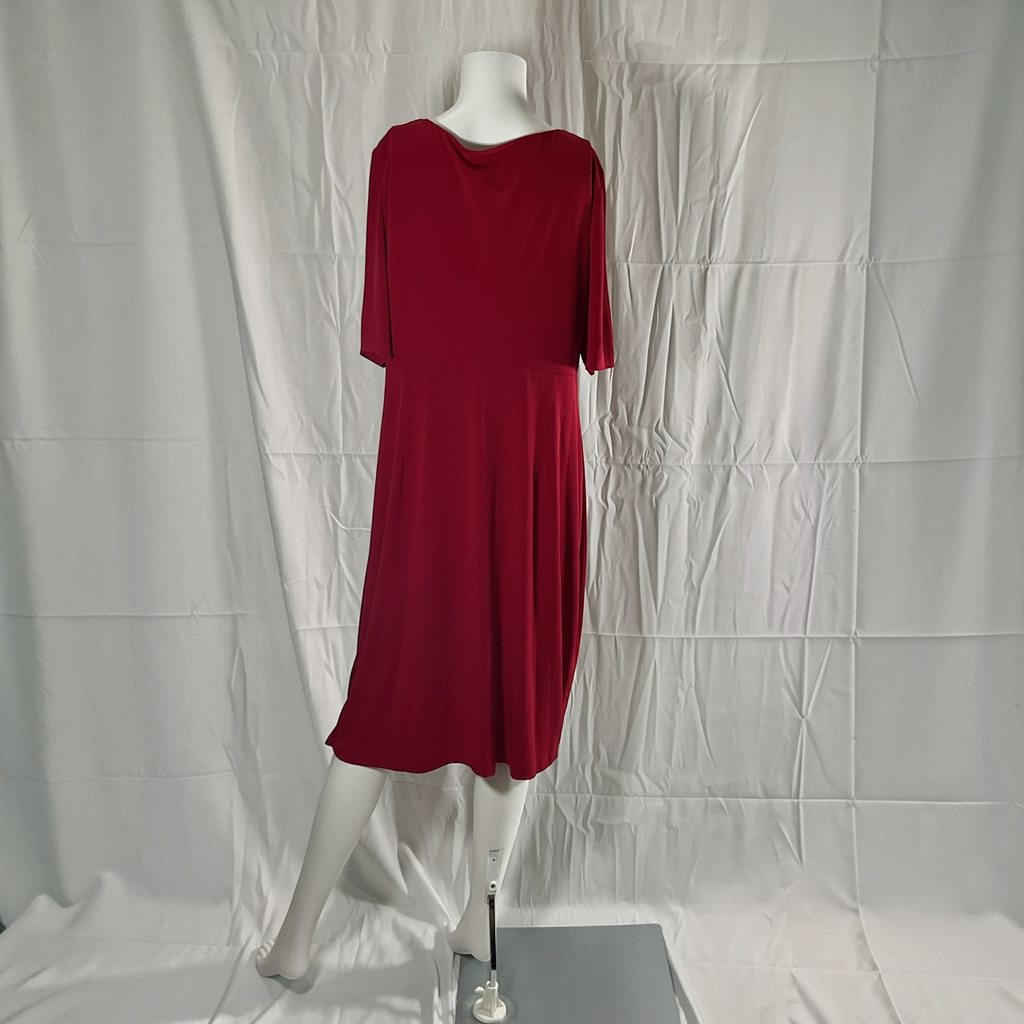 A red short-sleeve dress displayed on a white mannequin against a wrinkled white fabric backdrop.
