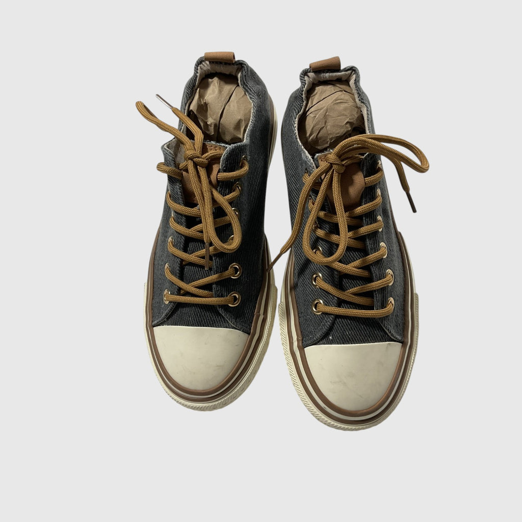Pair of gray sneakers with white laces on a light gray background
