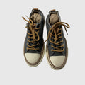 Pair of gray sneakers with white laces on a light gray background