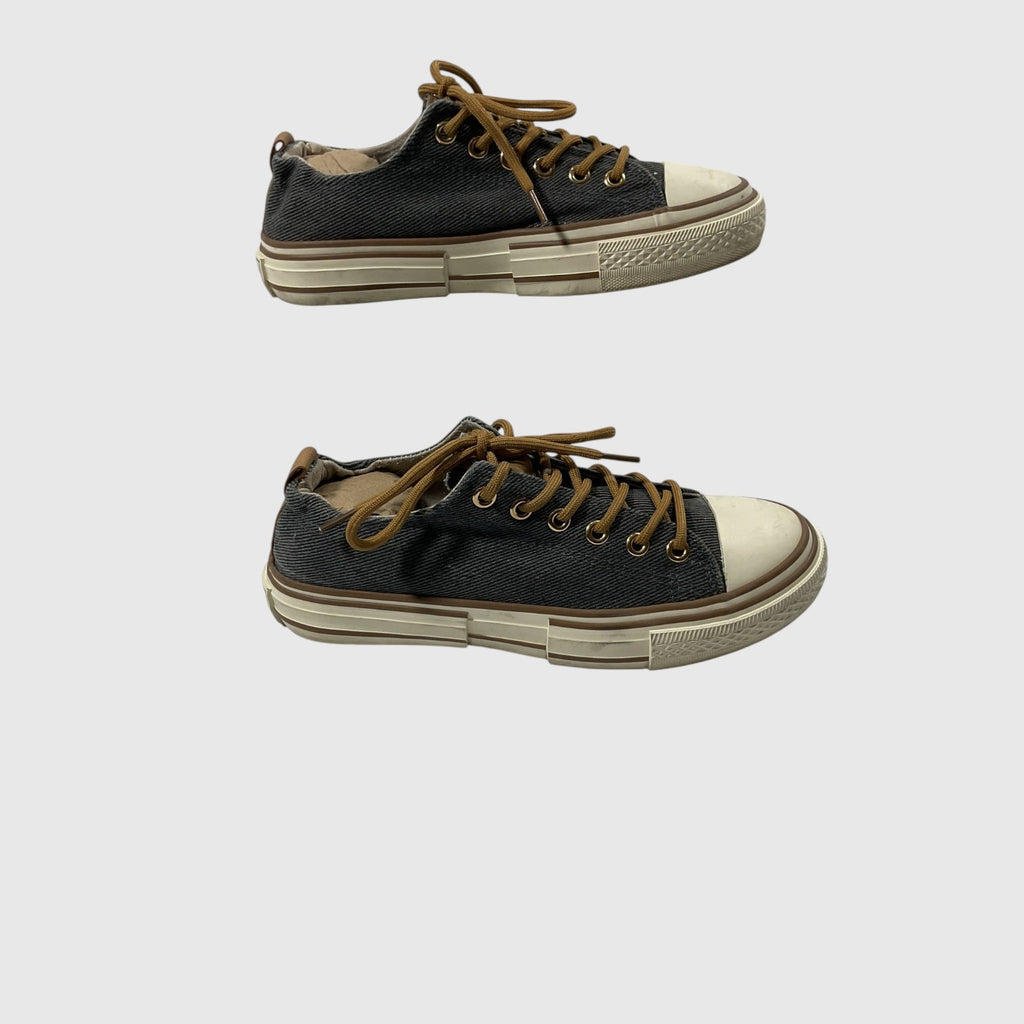Pair of gray sneakers with white laces on a light gray background