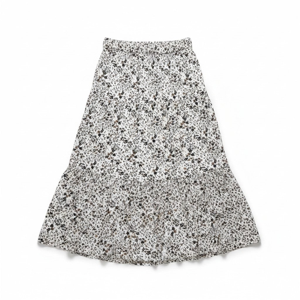 A tiered A-line skirt with an all-over black and brown floral print on a white background, laid flat against a white studio background.