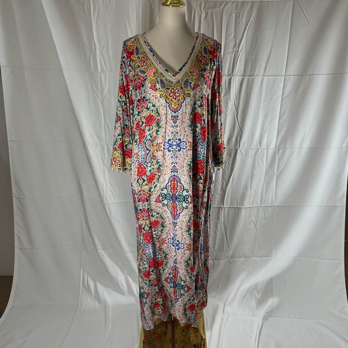 The Ornate Medallion & Floral Tapestry Print V-Neck Pom-Pom Trim Three-Quarter Sleeve Side Slit Relaxed Maxi Caftan Dress in Ivory, Crimson & Emerald by Soft Surroundings on a light background