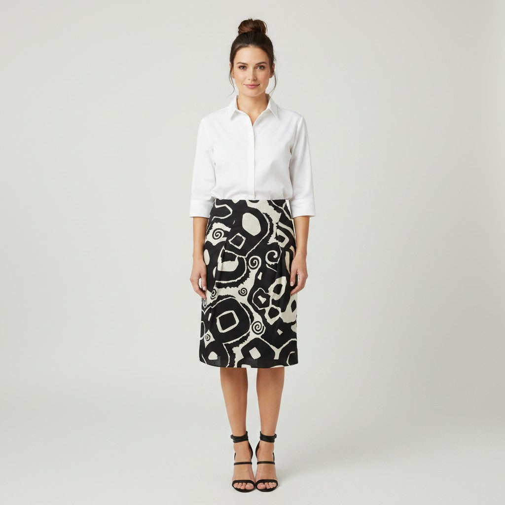 A woman wearing a white shirt with a black ad white skirt and black heels on a light gray background