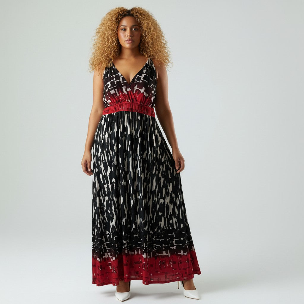 A woman modeling a sleeveless maxi dress with a black, white, and red abstract pattern, featuring a red smocked bodice and a red lace-trimmed hem, set against a plain light gray studio background.