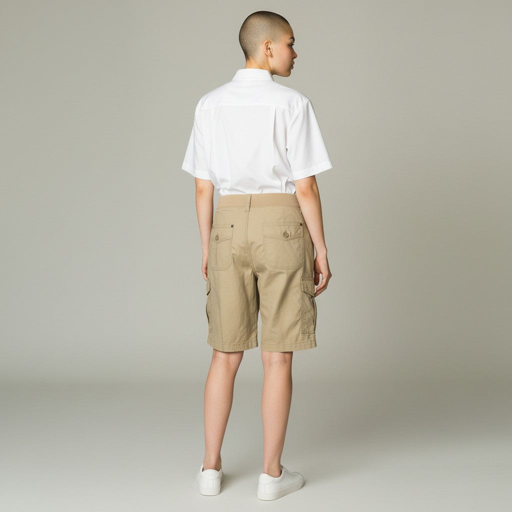 A model shown from the back wearing a white short-sleeve button-up shirt tucked into beige cargo shorts, paired with white sneakers, against a neutral light gray studio background.