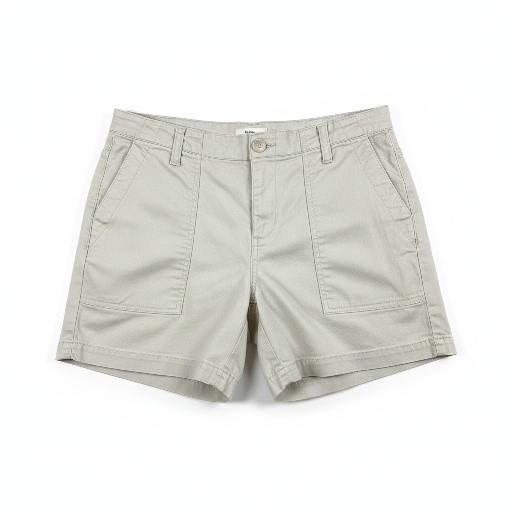 A pair of light beige utility shorts with a button closure, belt loops, and front patch pockets, shown flat on a white background.