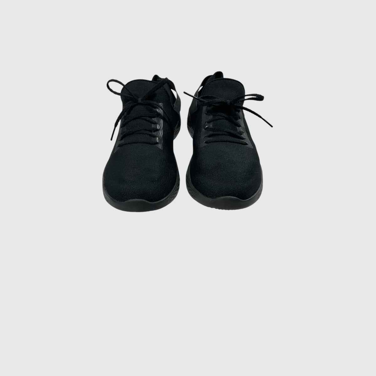 A pair of black low-top athletic sneakers shown from a top-down view against a light gray background.
