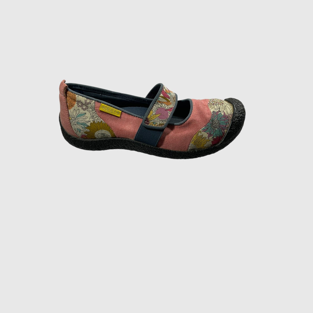 A single Mary Jane style shoe shown in profile against a light gray background. The shoe features a dusty pink fabric upper with patterned panels in yellow, blue, and green, a navy blue strap, and a black sole.