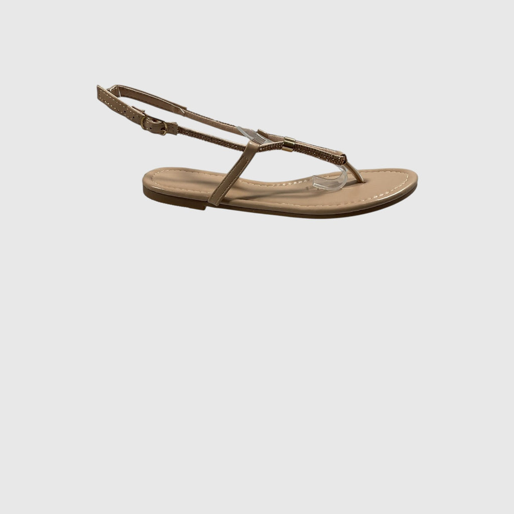 A pair of metallic gold T-strap sandals with adjustable ankle straps, displayed on a light gray reflective surface.