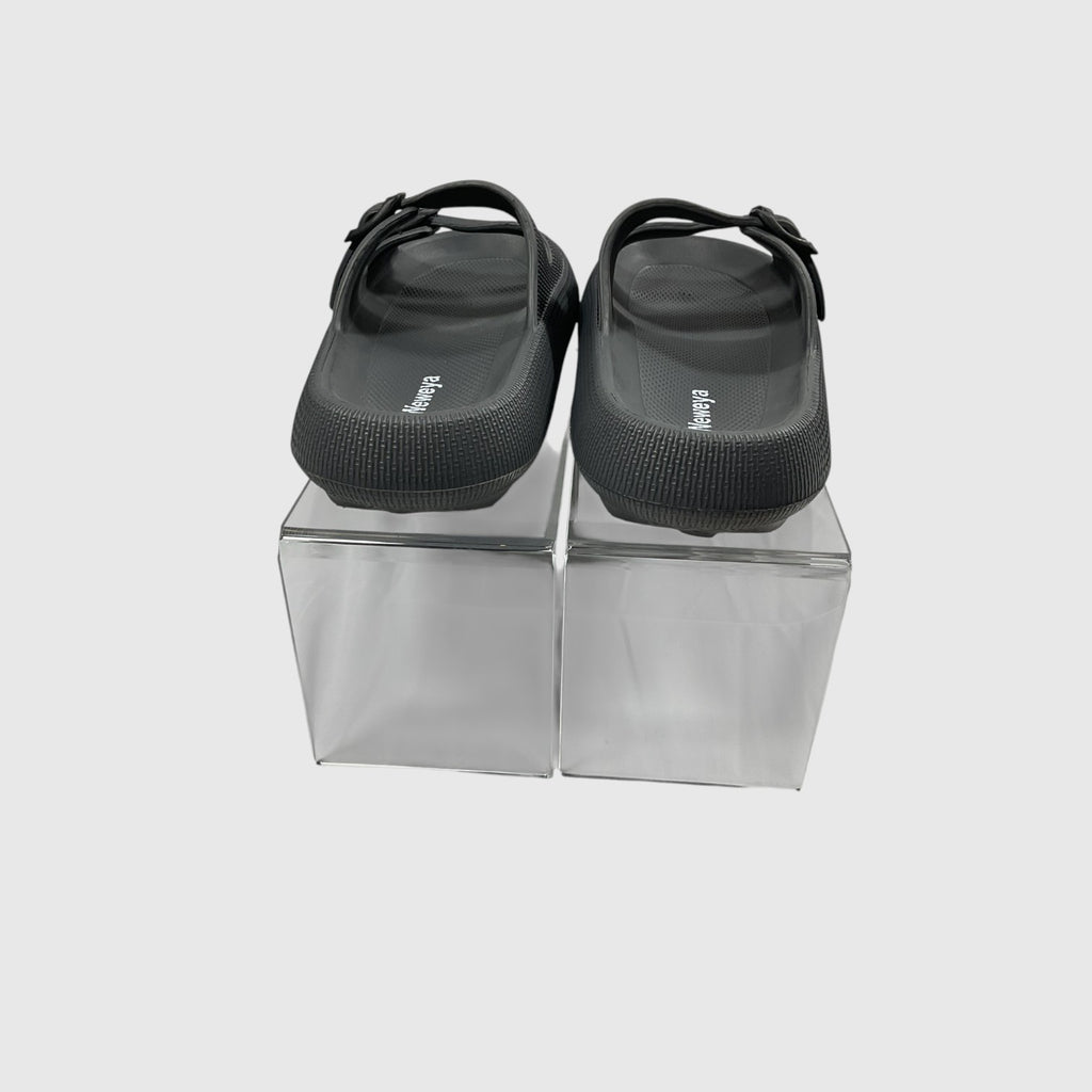 A pair of black slides on a light gray background.
