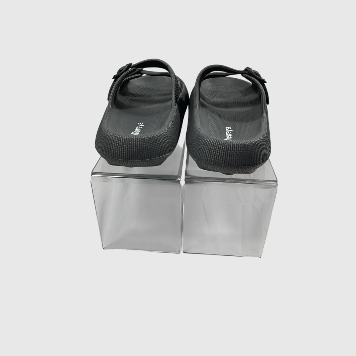 A pair of black slides on a light gray background.