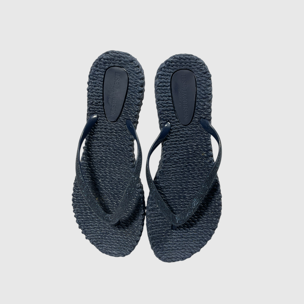 A pair of textured navy blue flip flops on a light gray background.
