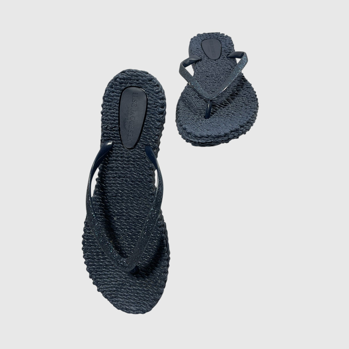 A pair of textured navy blue flip flops on a light gray background.