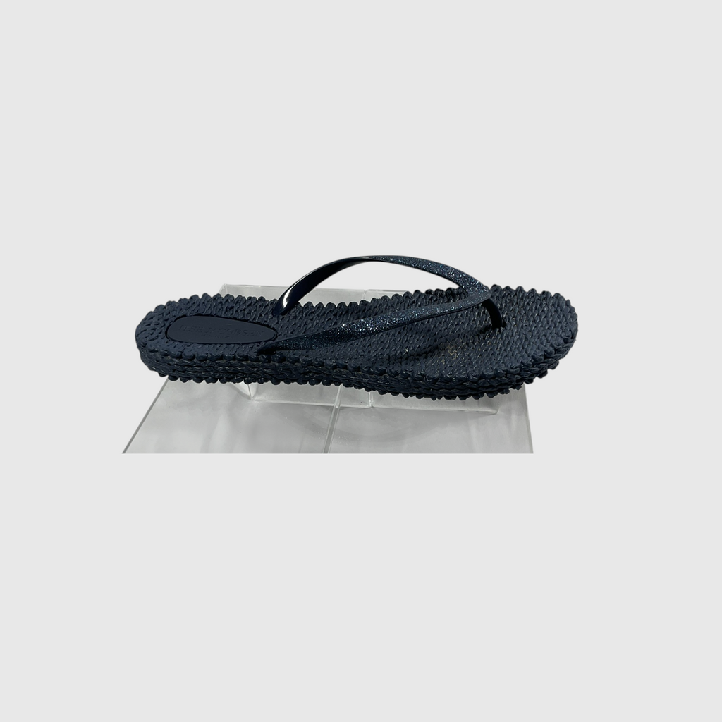 A pair of textured navy blue flip flops on a light gray background.