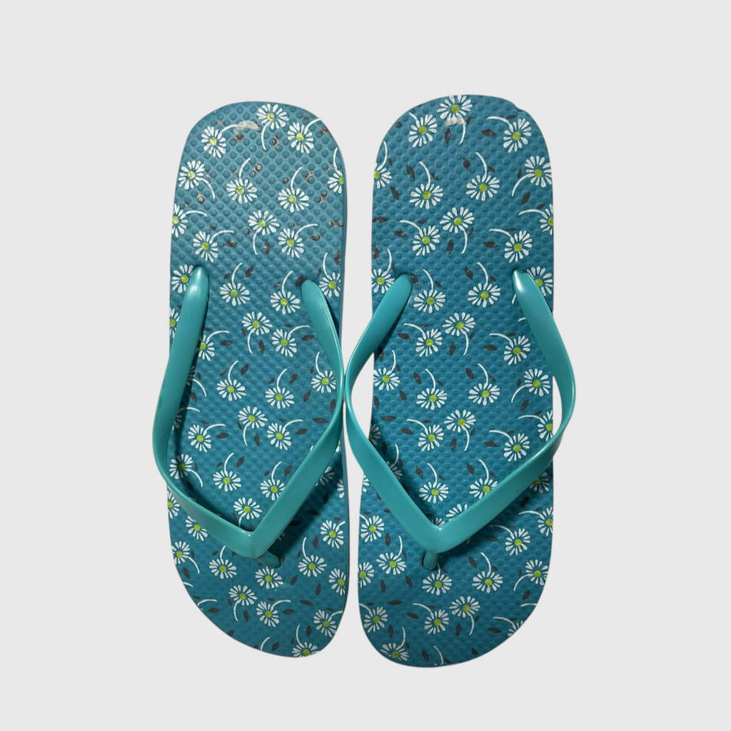 A pair of teal flip-flops with a white and yellow daisy floral pattern on the footbeds, shown against a light gray background.