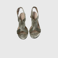 A pair of metallic silver slingback wedge sandals with crisscrossing elastic straps, shown from a top-down view on a light gray background.
