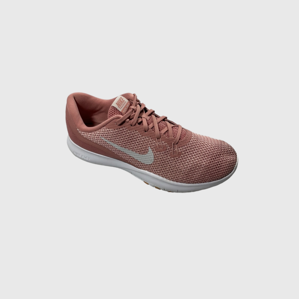 A single Nike running shoe in a dusty rose pink colorway, featuring a breathable mesh upper, matching laces, a light gray Swoosh logo, and a white midsole, shown against a solid light gray background.