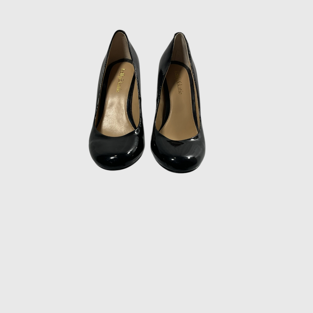 A pair of black patent leather pumps with a gold insole, shown from a top-down view on a light gray background.