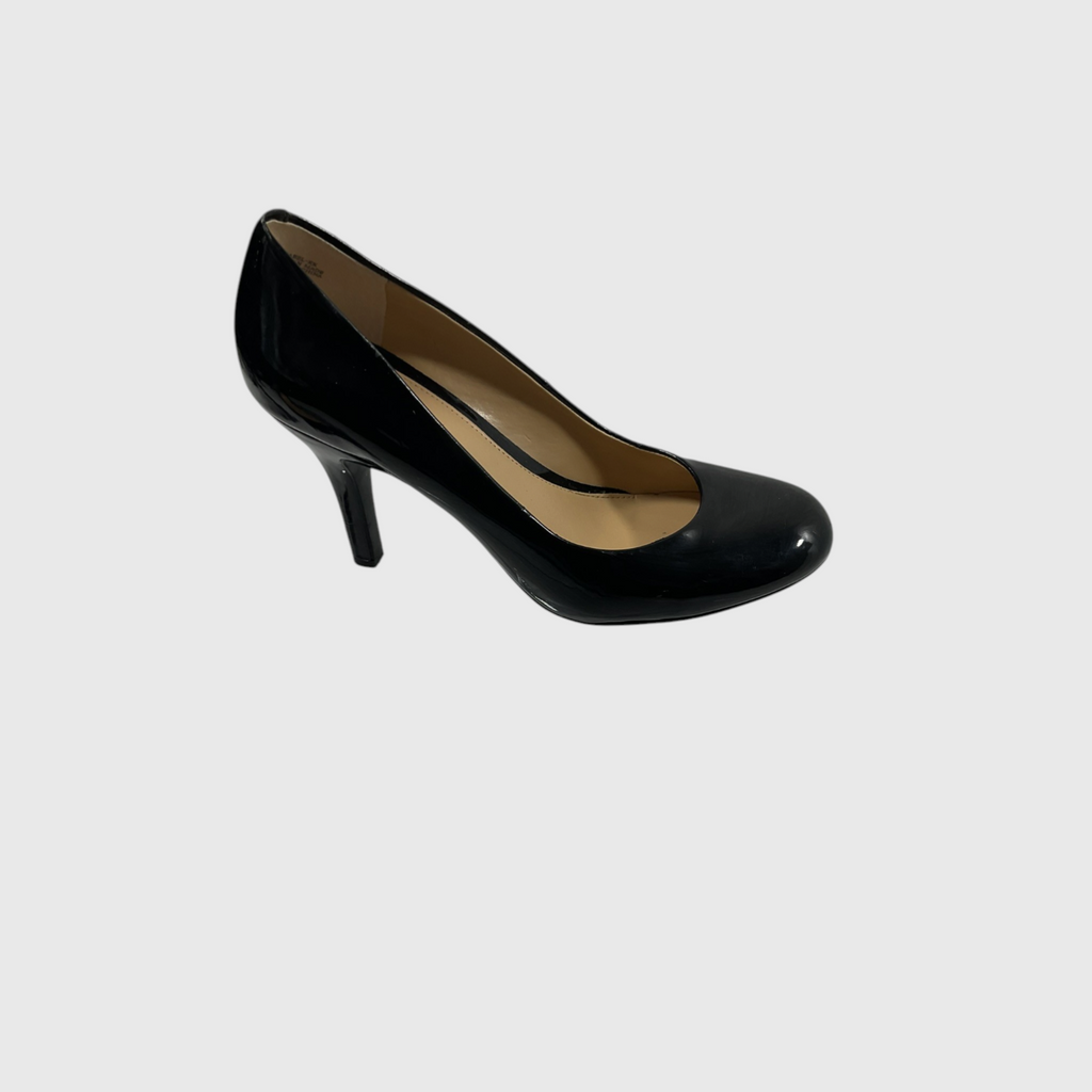 A single black patent leather pump with a mid-height stiletto heel, shown from a side profile against a light gray background.