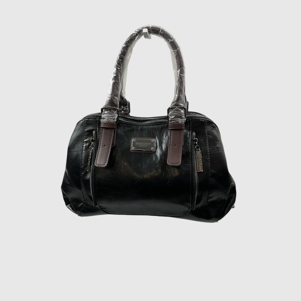 A black glossy patent leather handbag with brown leather trim and a silver-tone metal plaque on the front, shown against a light gray background.